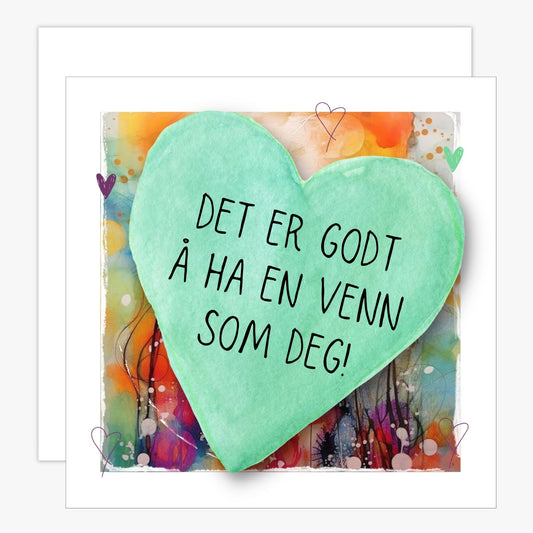 Kort med lysegrønt hjerte med tekst "Det er godt å ha en venn som deg" og bakgrunn i fargerik blomstereng. Konvolutt er inkludert.