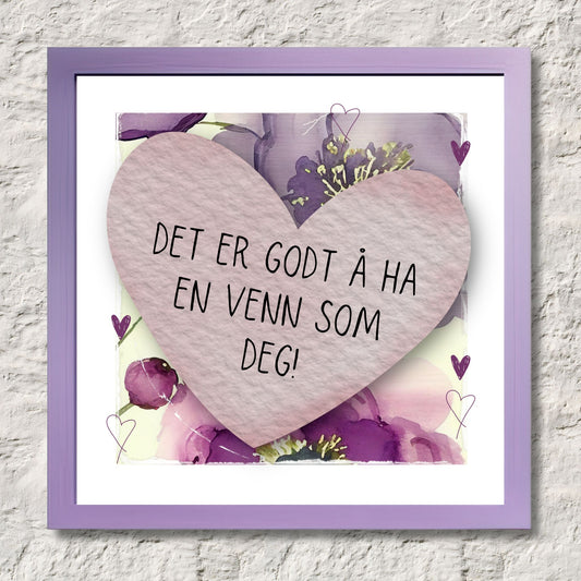 Go'ord plakat med et lilla hjerte med teksten "Det er godt å ha en venn som deg" på en bakgrunn med blomstermotiv i lilla, burgunder og grønt. Illustrasjon som viser plakat i ramme.