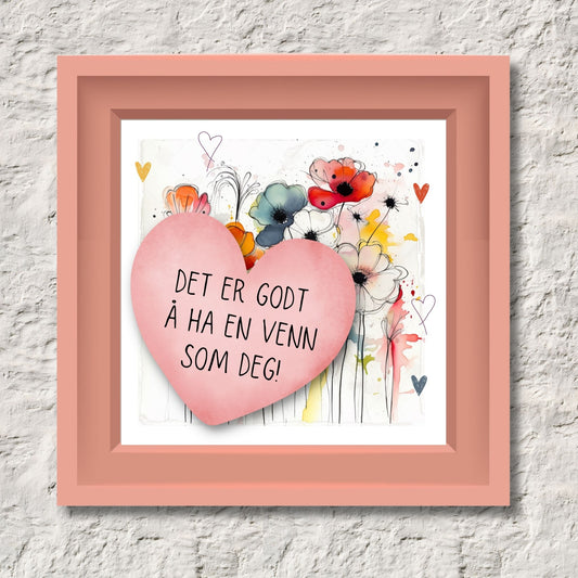 Plakat med rosa hjerte og tekst "Det er godt å ha en venn som deg" - og et motiv med blomster i gul, rød, hvit, blå og oransje. Med hvit kant på 1,5 cm. Illustrasjon viser plakat i rosa ramme.