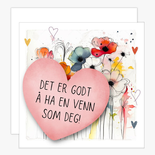 Kort med rosa hjerte med tekst "Det er godt å ha en venn som deg" og bakgrunn med fargerik blomstereng. Konvolutt er inkludert.