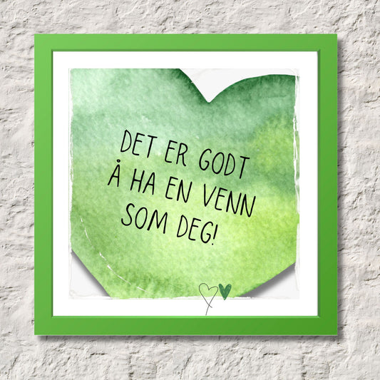 Plakat med grønt hjerte og tekst "Det er godt å ha en venn som deg". Med hvit kant på 1,5 cm. Illustrasjon viser plakat i grønn ramme.