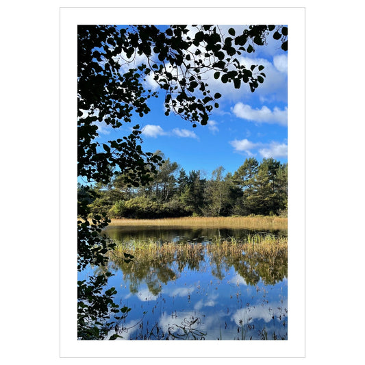 Dette motivet fanger en perfekt dag i september, med speilblankt vann som reflekterer den klare blå himmelen og de omkringliggende trærne