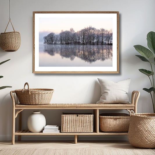 Dette kunstverket, tilgjengelig som plakat og lerret, viser en stille skog ved vannkanten, innhyllet i et lett vinterdis og med trærne dekket av frost. Illustrasjonsfoto viser motivet som plakat i lys ramme.