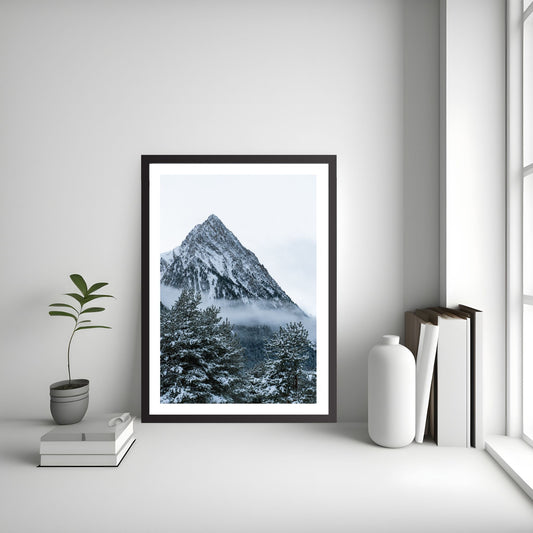 Snøkledd granskog  og ruvende fjelltopp. Fotografi  som plakat eller lerret. Plakat har en hvit kant rundt som gir dybde og fremhever motivet. Illustrasjonen viser fotografiet stående i gulvet  i en sort ramme,