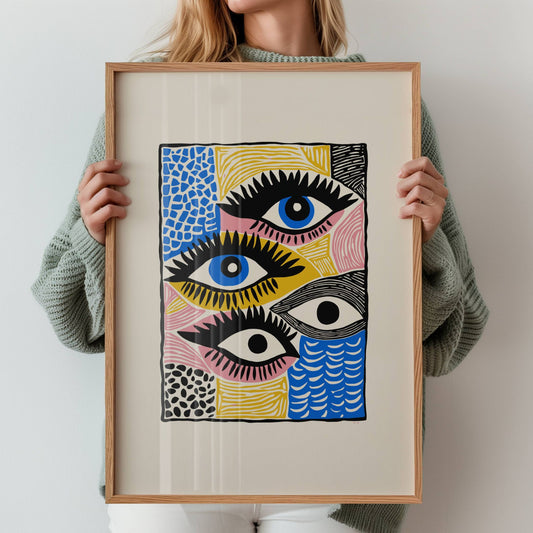 Vision Blocks er en særegen og uttrykksfull plakat med gjentatte øyemotiver og fargesterke felt i rosa, blått, gult og svart. Illustrasjon viser plakat med bred kant i eik ramme.