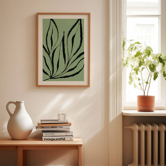 Denne unike plakaten kombinerer botanisk inspirasjon med kunstnerisk frihet. De sorte penselaktige linjene danser over en dus grønn bakgrunn og skaper et uttrykk som er både dynamisk og balansert. Illustrasjon viser plakat i eik ramme.