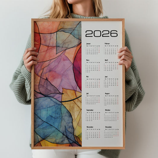 Kalender 2026 med abstrakt bladmotiv i farger og moderne kalenderlayout. Illustrasjon viser kalender i eik ramme.