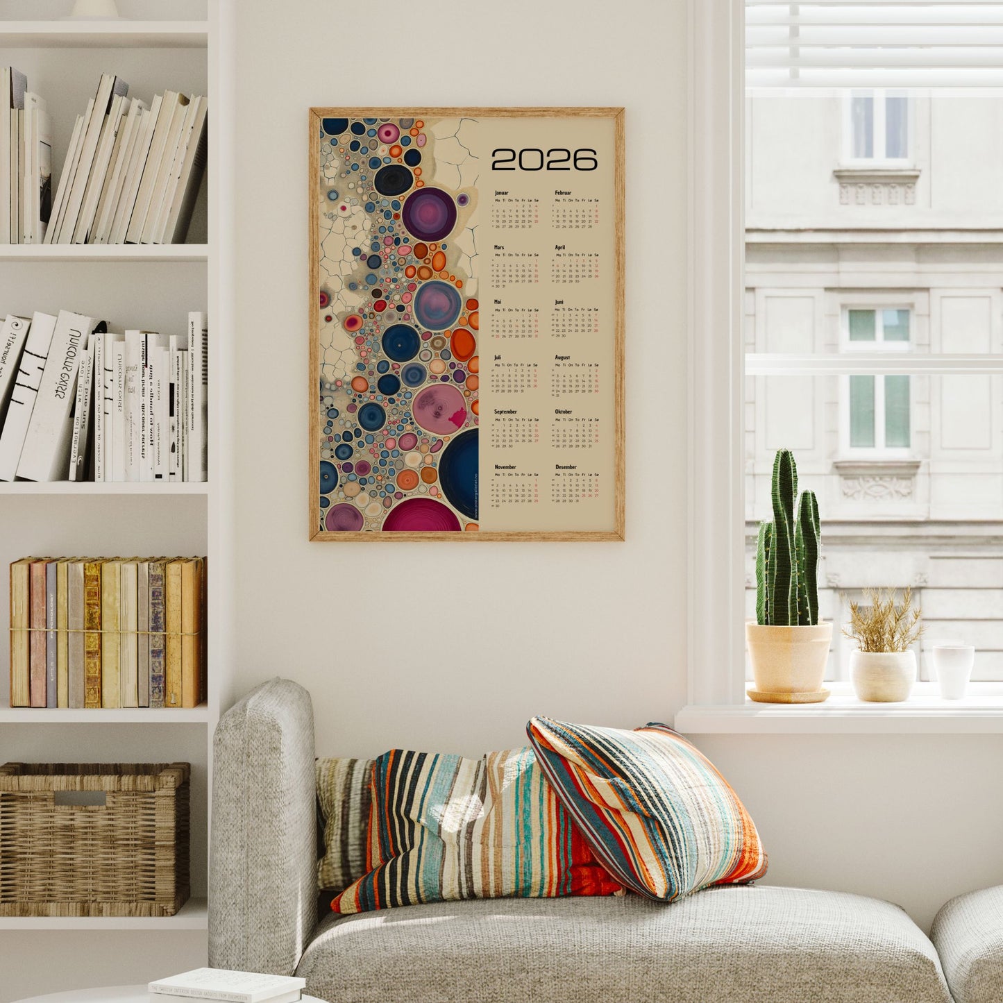 Kalender 2026 med fargerike abstrakte sirkler i ulike størrelser og årskalender på høyre side. Illustrasjon viser kalender i eik ramme.