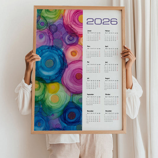 Kalender 2026 med alkoholink-inspirerte sirkler i klare, fargerike toner. Illustrasjon viser kalender i eik ramme.