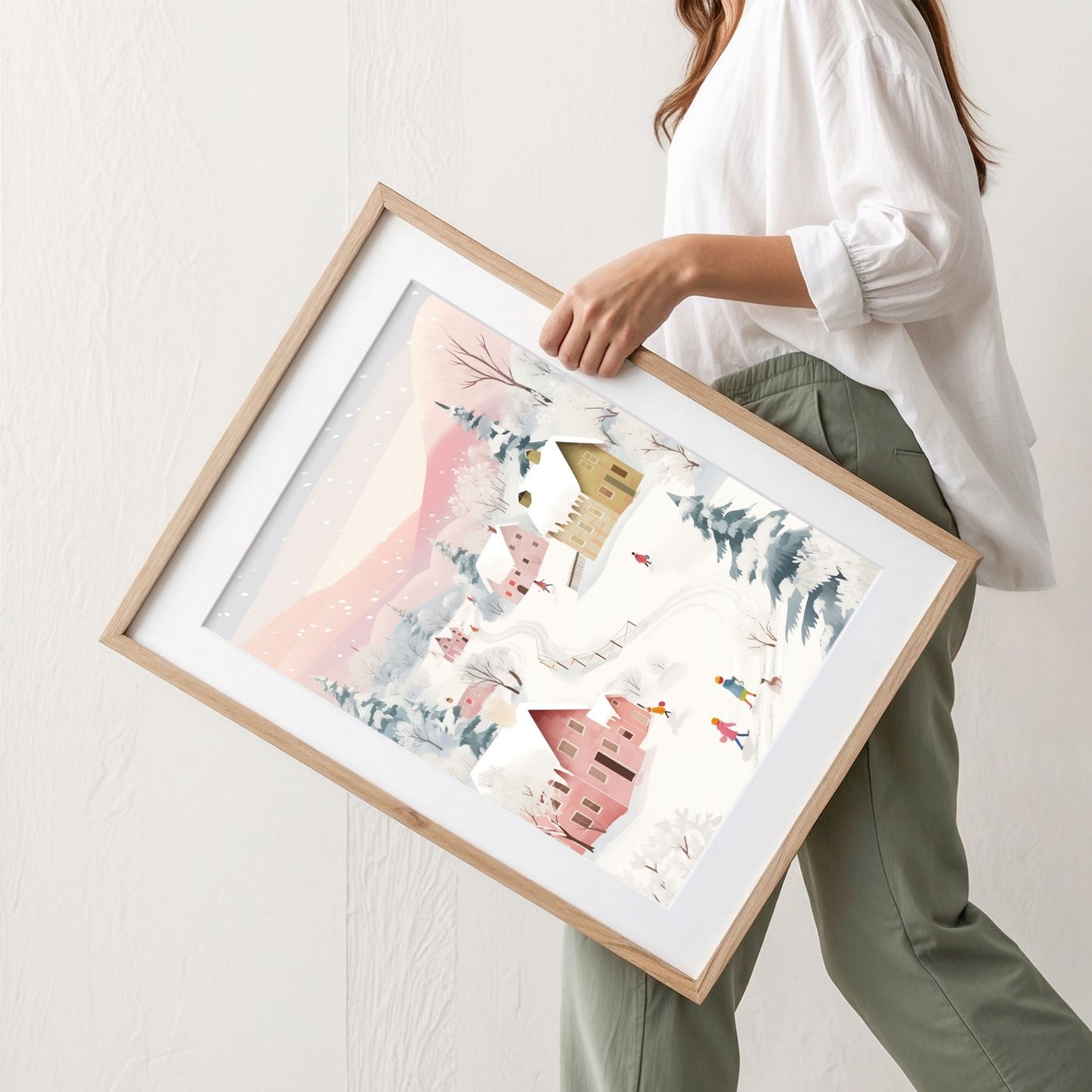 Vinterglede i Pastellbygda plakat med pastellfargede hus, lekende figurer og rosa vinterfjell. Illustrasjonen viser plakat med passepartout i eik ramme.