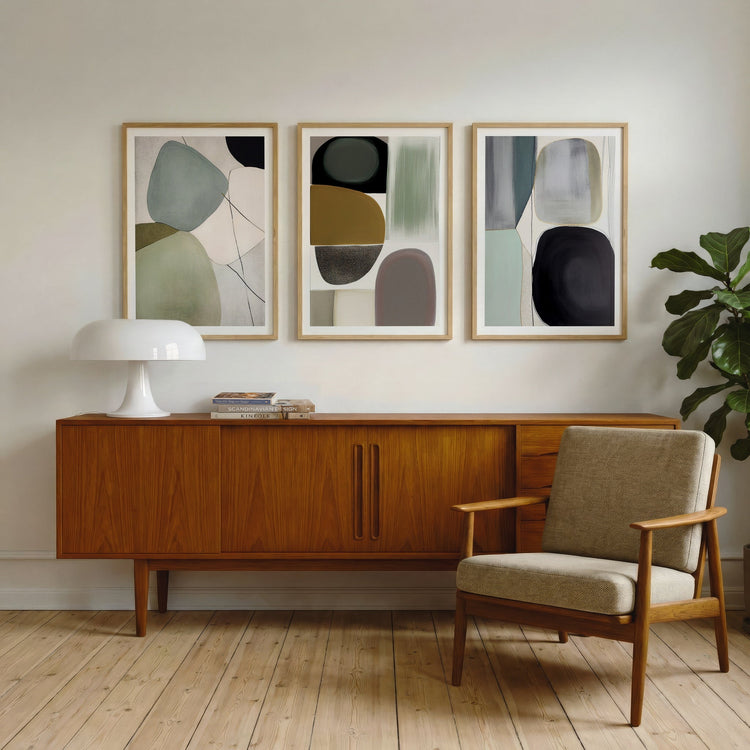 Tre grafiske plakater fra Soft Balance Collection i eikerammer i et lyst nordisk interiør