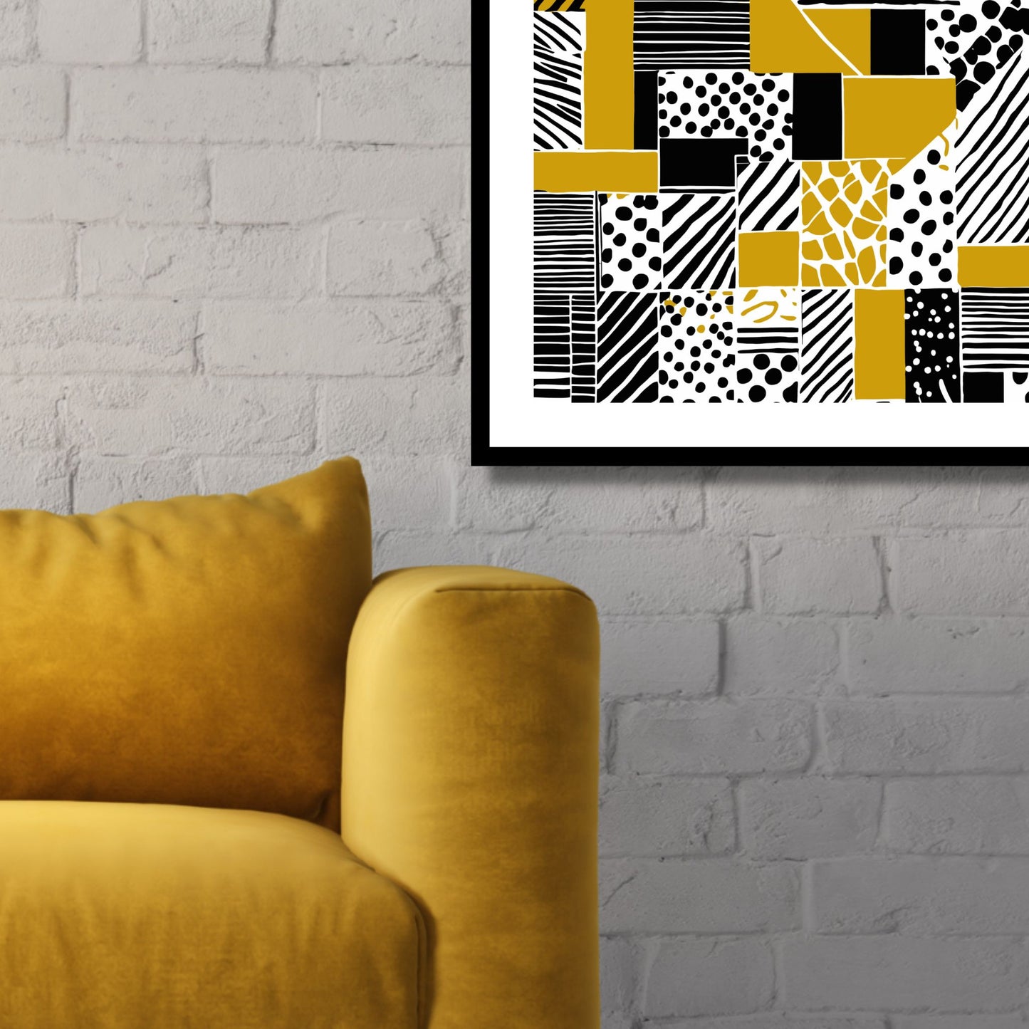 Kvadratisk plakat med abstrakt mønster i fargene oker, sort og hvit. Det er en hvit kant rundt plakaten. Her er den rammet inn i sort ramme, og henger på en hvit murvegg ved siden av en gul stol.