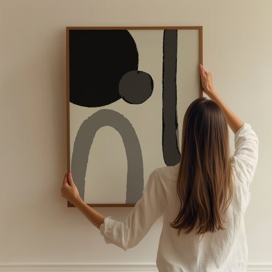Dette moderne kunstverket fremhever flytende, geometriske former i monokrome gråtoner og svart, og skaper en harmonisk balanse mellom det kunstneriske og det minimalistiske. Illustrasjon viser plakat uten hvit kant i ramme av eik.