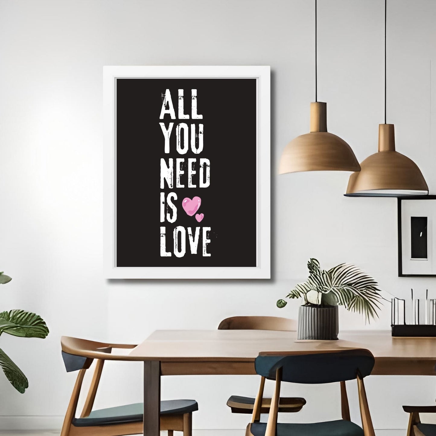 ALL YOU NEED IS LOVE - grafisk tekstplakat med hvit tekst på sort bakgrunn, og to rosa hjerter. Illustrasjon viser plakat i hvit ramme på en vegg ved et spisebord.