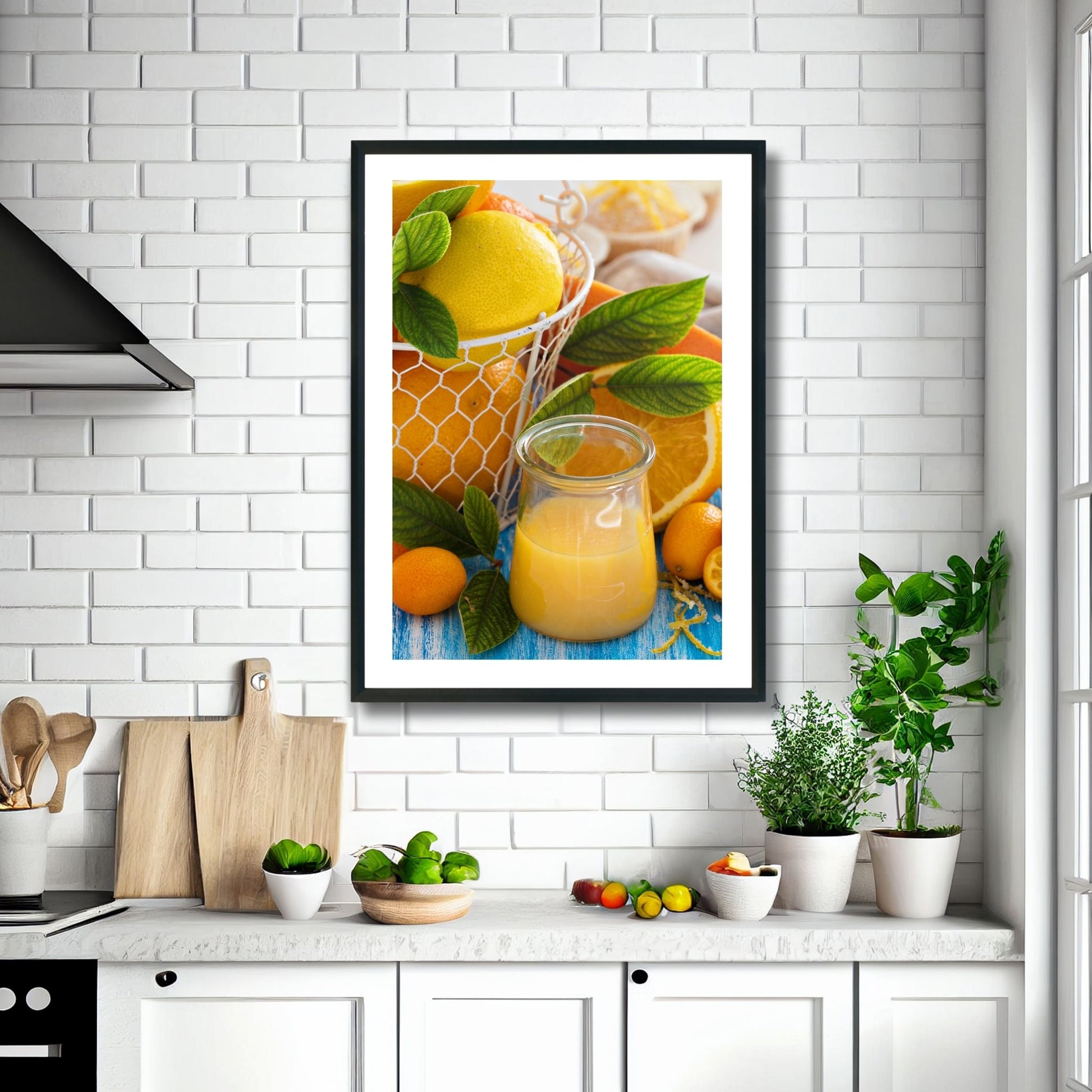 Fotoplakat av appelsiner og et glass med juice. Illustrasjonsbildet viser plakat i sort ramme over en kjøkkenbenk.