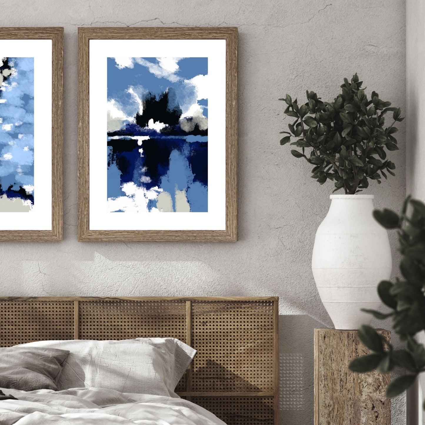Blue Abstract No2 er en grafisk plakat med et motiv i blåfarger med innslag av hvit og beige. Plakaten har en bred hvit kant som gir bildet dybde og fremhever motivet. Illustrasjon viser plakaten i en ramme i eik på en vegg over en seng. 