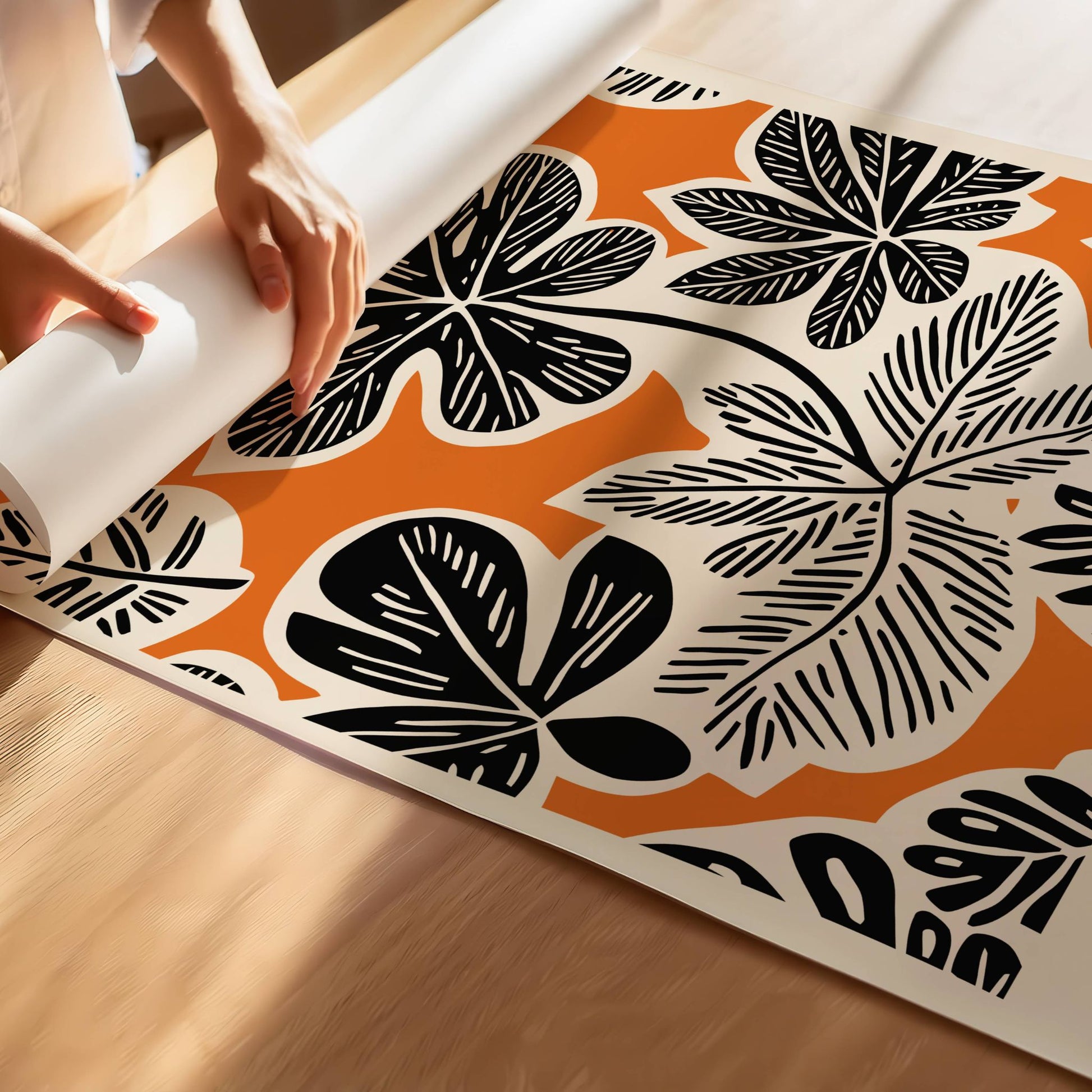 Bold Botanica kombinerer kraftige, svarte bladformer med en varm oransje bakgrunn i retroinspirert design. Illustrasjon viser motiv med smal kant på print.
