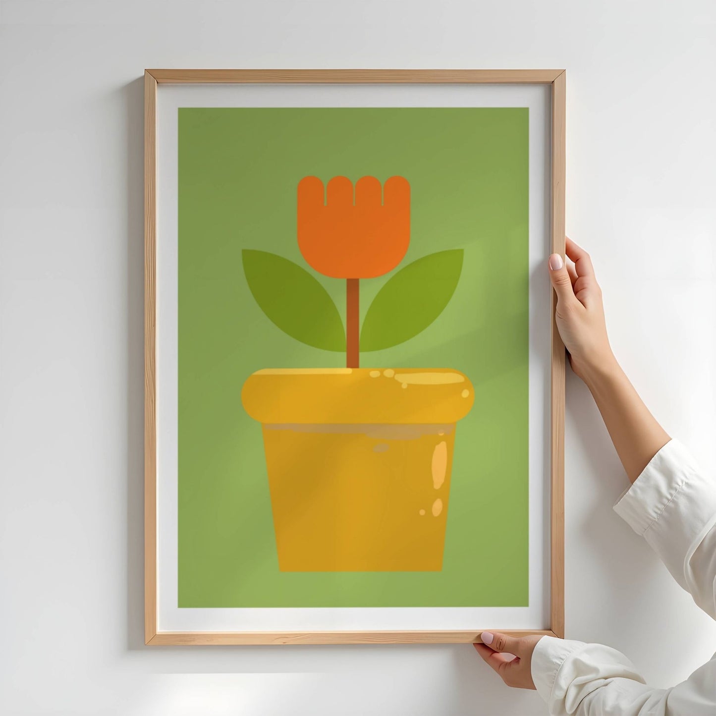 Bold Botanical No10 er en enkel og ikonisk blomst i kraftig oransje står rank i en gyllen blomsterpotte. Med to mørkegrønne blader og en stilisert form mot en frisk grønn bakgrunn, formidler motivet både retroglede og moderne minimalisme. Illustrasjon viser plakat i eik ramme.