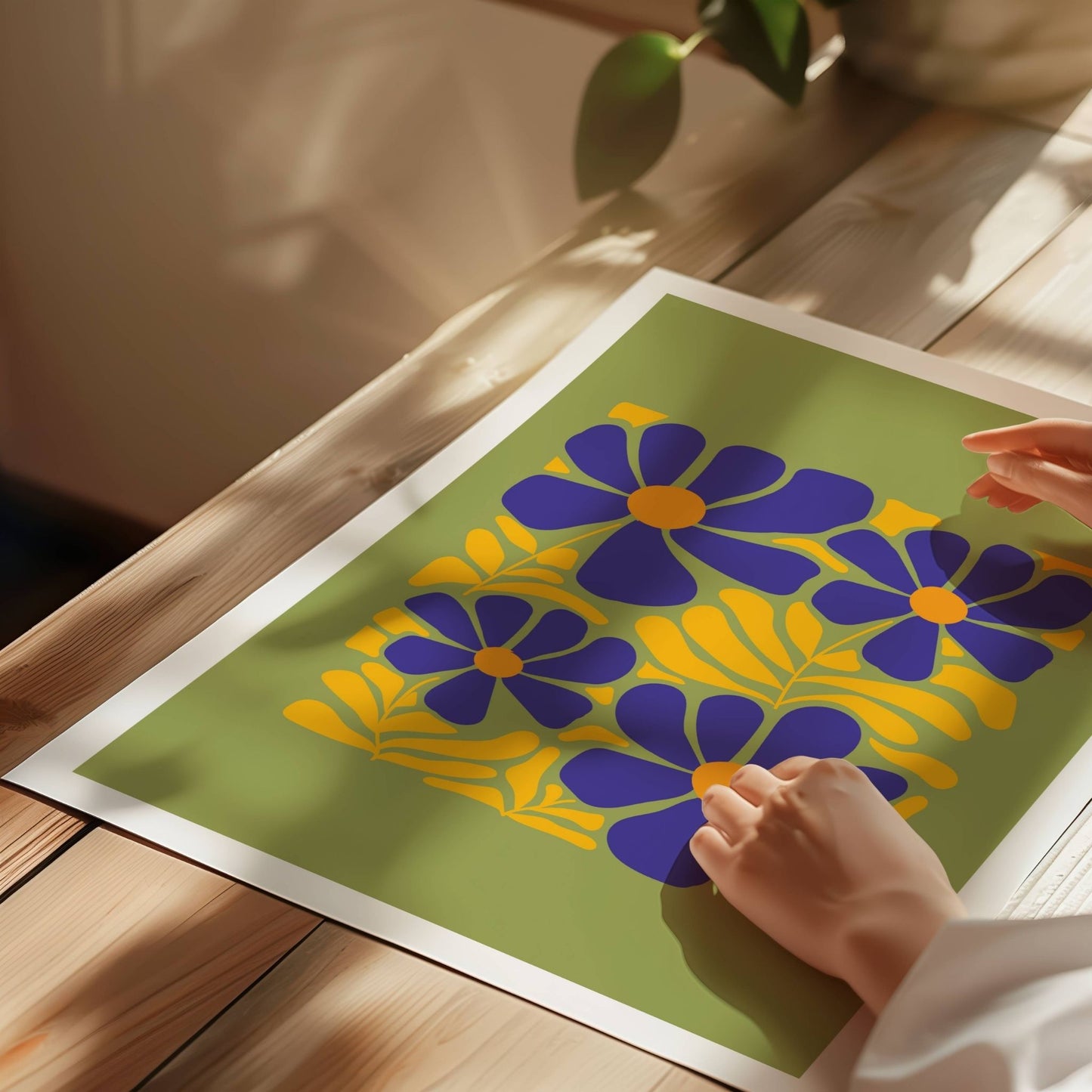 Bold Botanical No6&nbsp;viser fre store blomster i dyp lilla med solgule sentre er omgitt av dekorative blader i samme varme gulfarge. Alt er satt mot en olivengrønn bakgrunn som fremhever det sterke fargespillet. Illustrasjon viser plakat på print.