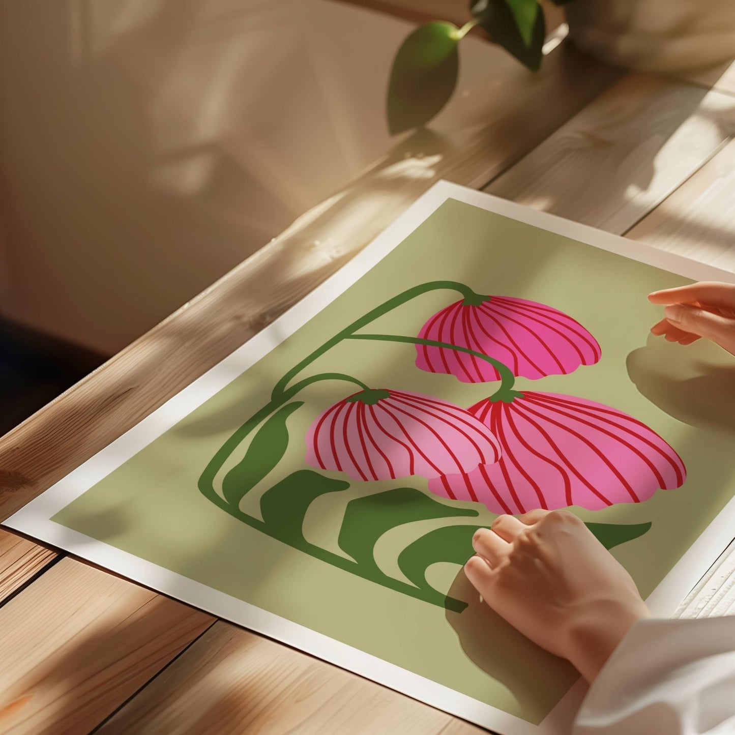 Bold Botanical No8 byr på tre nikkende blomster i livlige rosatoner med elegante røde linjer bøyer seg mot venstre, som i en stille dans. Illustrasjon viser plakat på print.