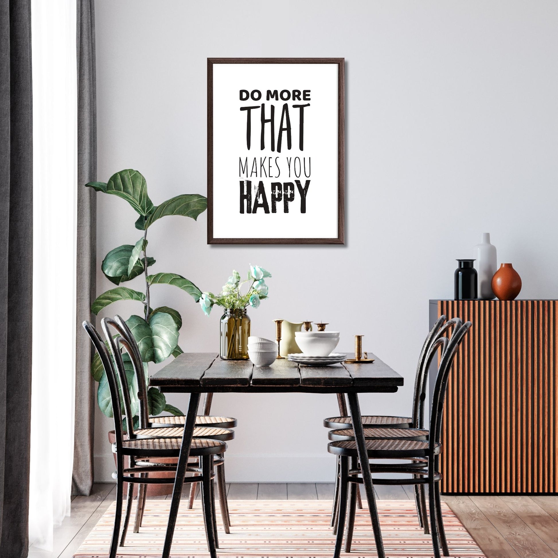 "Do more that makes you happy" tekstplakat. Sort skrift på hvit bakgrunn. Illustrasjon viser plakat i ramme på en vegg i en spisestue.