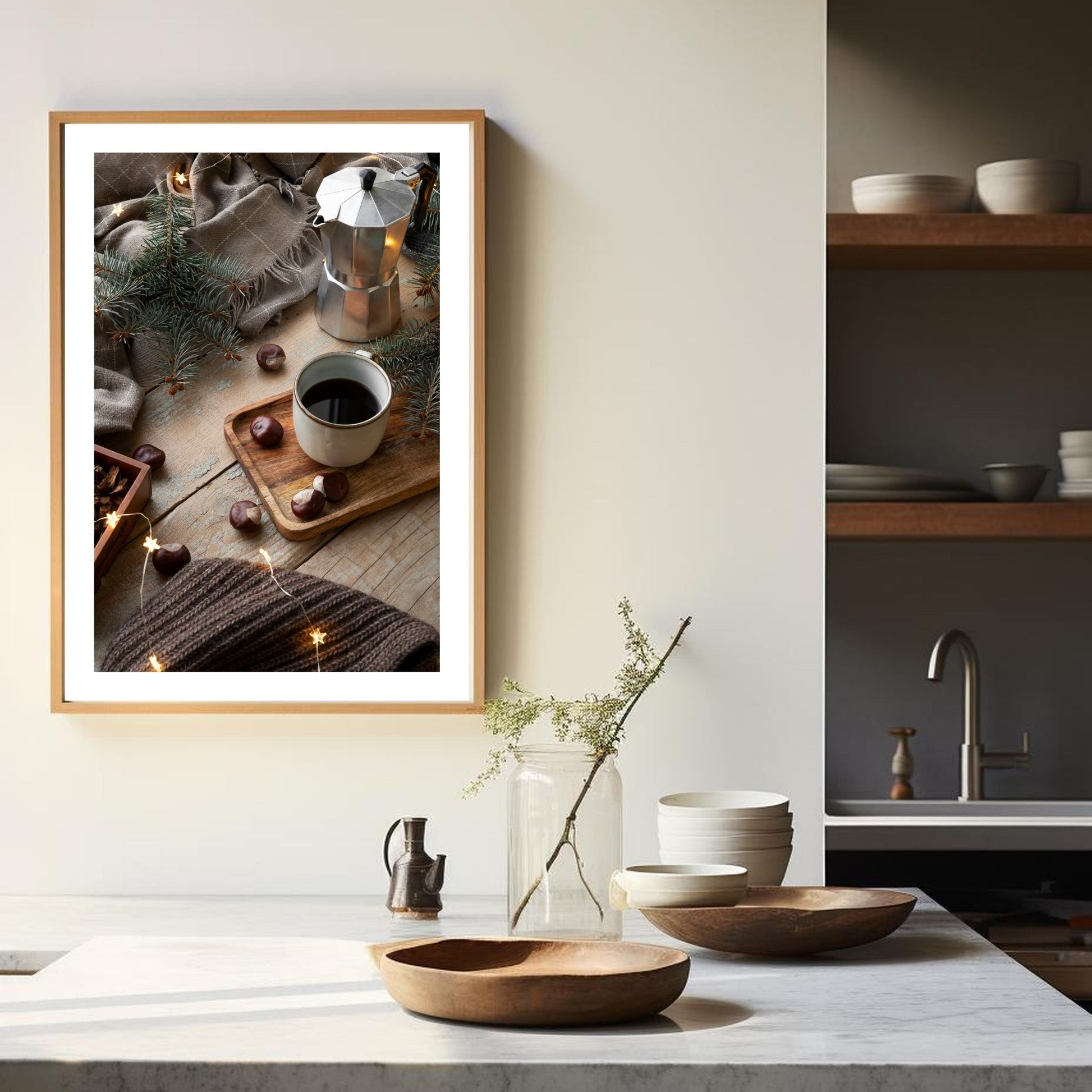 Plakat med dekorativt førjulsmotiv av en espressokanne, kaffekopp og julepyntet bord. Illustrasjonen viser plakaten i eikeramme som henger på en vegg over en kjøkkenbenk.