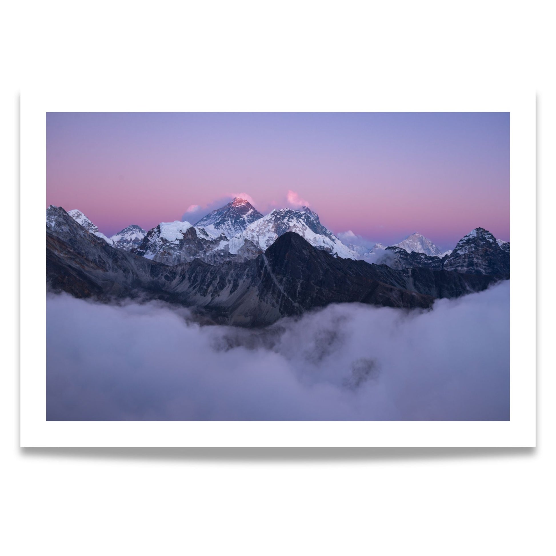 Dette fantastiske bildet viser Mount Everest, dekket av snø og innhyllet i tåkedekte skyer under en vakker, rosa-lilla skumringshimmel. 