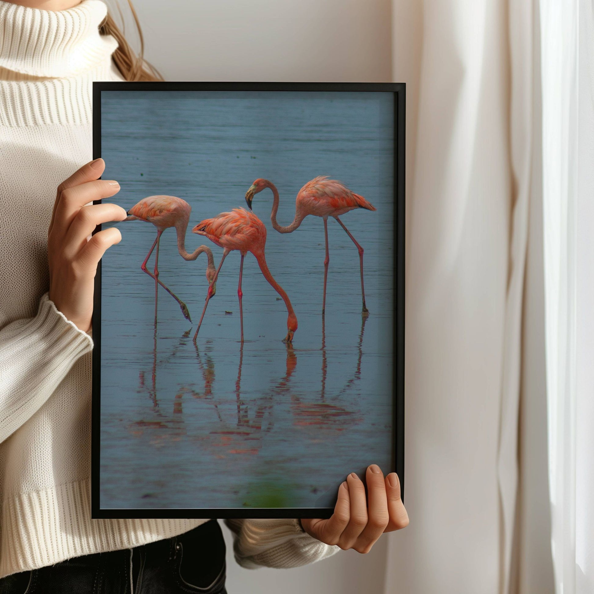 Dette fargerike naturmotivet fanger en gruppe flamingoer i stille vann, med vakre refleksjoner og rolige omgivelser. Illustrasjon viser motivet som plakat uten hvit kantlinje i sort ramme.