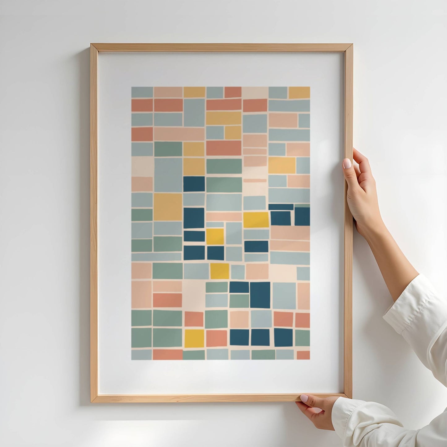 Geo Harmony består av rektangulære former i myke, balanserte fargetoner som blå, grønn, gul og terrakotta. Illustrasjon viser plakat i eik ramme.