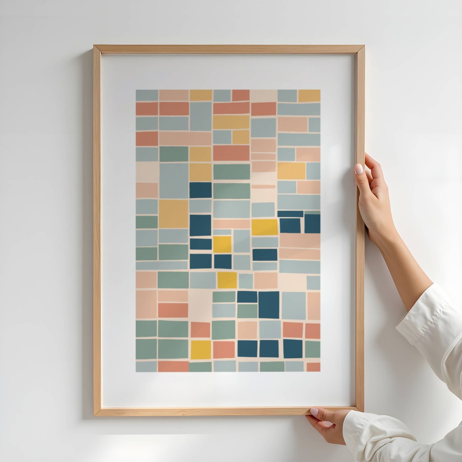 Geo Harmony består av rektangulære former i myke, balanserte fargetoner som blå, grønn, gul og terrakotta. Illustrasjon viser plakat i eik ramme.