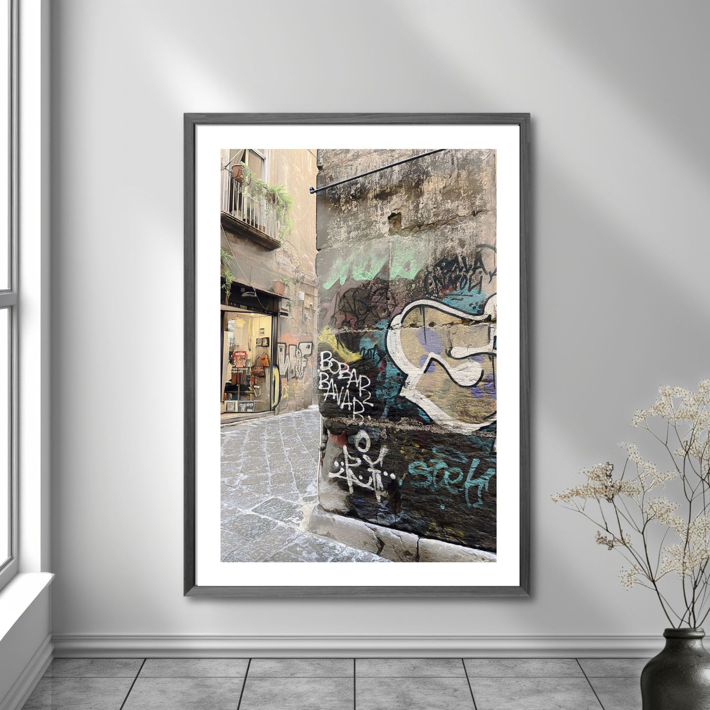 Graffiti Napoli. Dette levende bildet, tatt fra et gatehjørne i gamlebyen, gir deg en følelse av autentisitet og opplevelse av den lokale kulturen og et glimt av Napoletansk gatekultur. Illustrasjonsbilde viser fotografiet i ramme på en vegg.