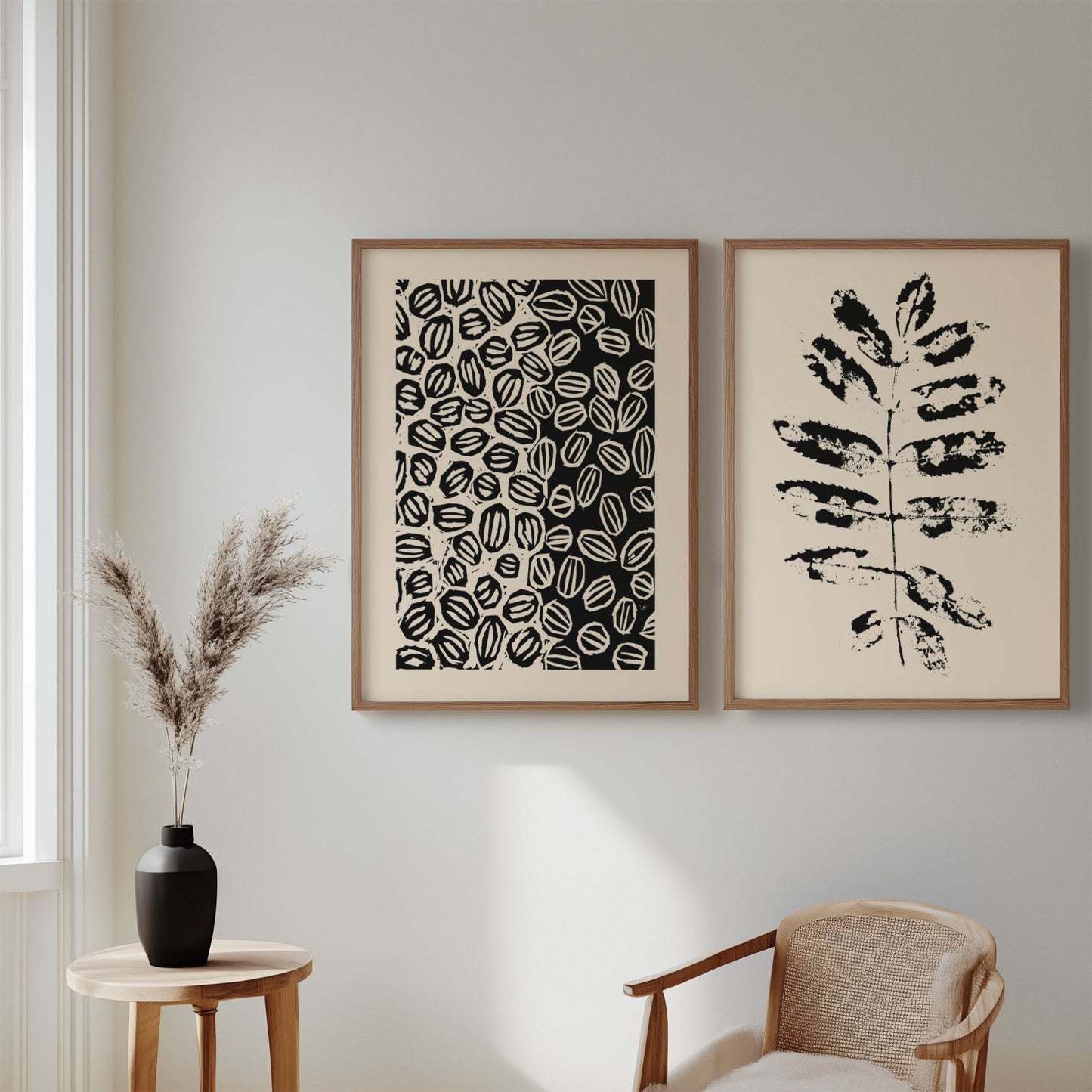 Illustrasjon viser plakatene Grafisk og Abstrakt Mønster Plakat og Minimalistisk Botanisk Plakat – Abstrakt Svart Bladdesign som henger i eikerammer på en stuevegg.