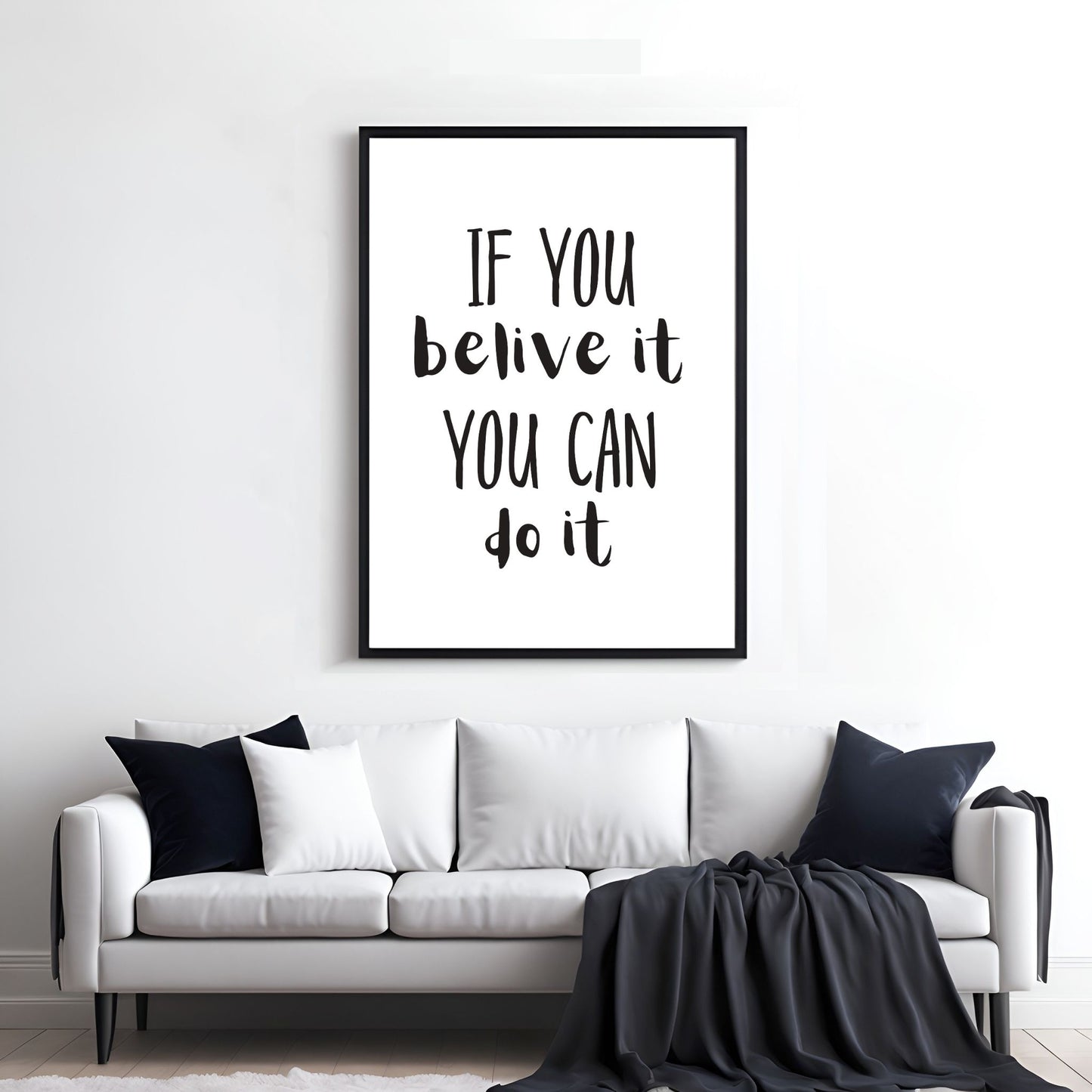 Grafisk tekstplakat med sort skrift på hvit bakgrunn og tekst "If you belive it, you can do it". Illustrasjon viser plakat i sort ramme på en vegg over en sofa.