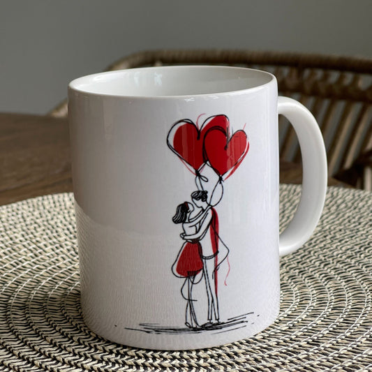 Dette romantiske kruset har en søt håndtegnet illustrasjon av et omfavnende par med røde ballonger, kombinert med en leken og kjærlighetsfylt typografi.