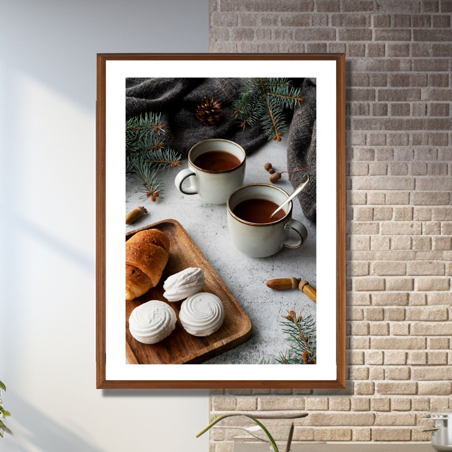 Plakat med dekorativt julemotiv av to kaffekopper og noe søtt til kaffen. Illustrasjon av plakat i eikeramme som henger på en vegg.