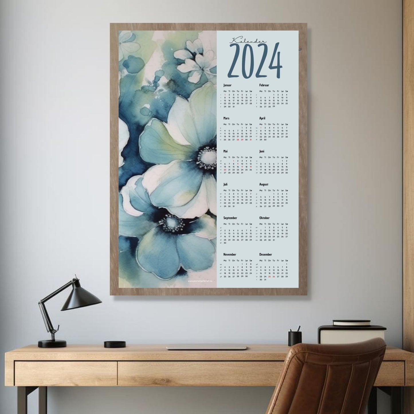 Kalender 2024 i grafisk print. Halve vertikale side har et grafisk floralt motiv i duse blå nyanser. fargenyanser. Den andre halvdelen er påført 12 måneder med ukenummer og anmerket høytidsdager. Miljøbilde av kalender i eikeramme som henger på en vegg.