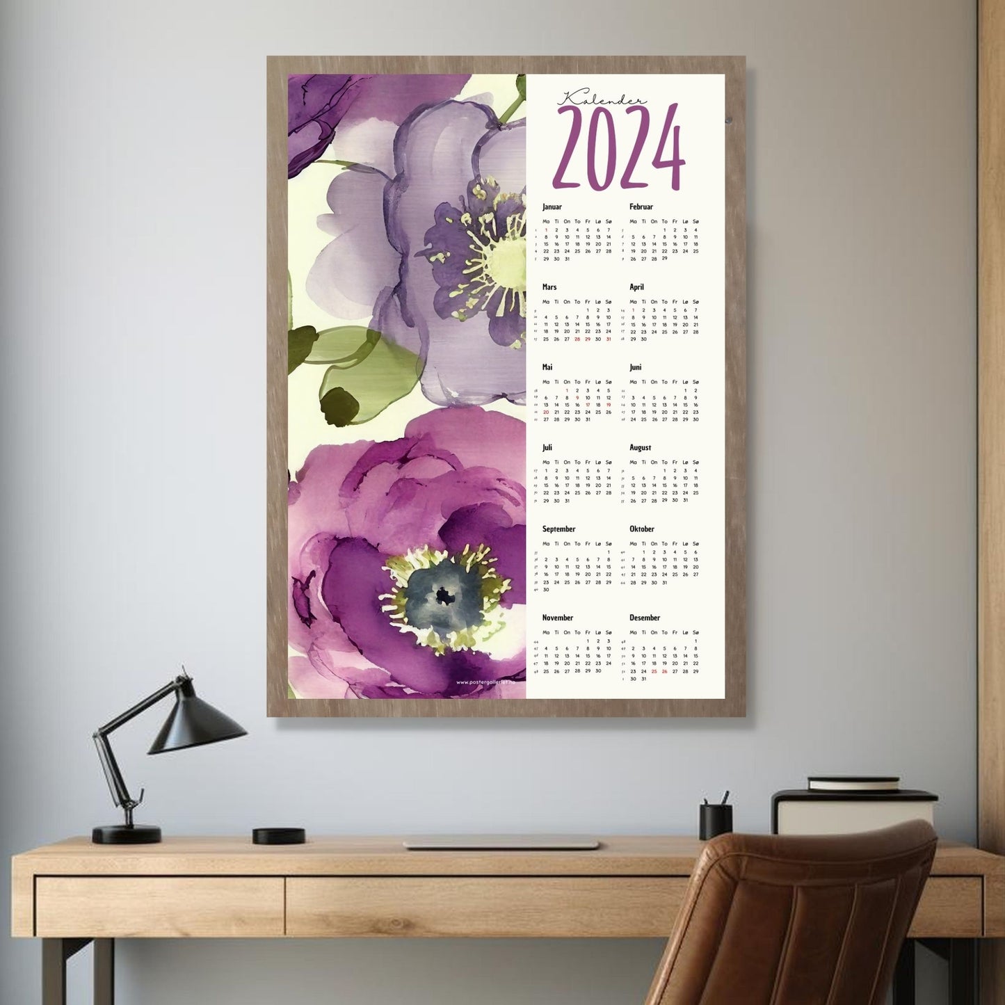 Kalender 2024 i grafisk print. Halve vertikale side har et grafisk floralt motiv i friske lilla fargenyanser. fargenyanser. Den andre halvdelen er påført 12 måneder med ukenummer og anmerket høytidsdager. Miljøbilde av kalender i eikeramme som henger på en vegg.