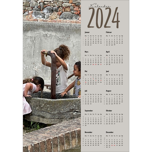 Kalender 2024 i grafisk print med fotomotiv. Halve vertikale side er et fotografi av noen småjenter som avkjøler seg ved en vannfontene i Grinzane, Italia. Den andre halvdelen er påført 12 måneder med ukenummer og anmerket høytidsdager.
