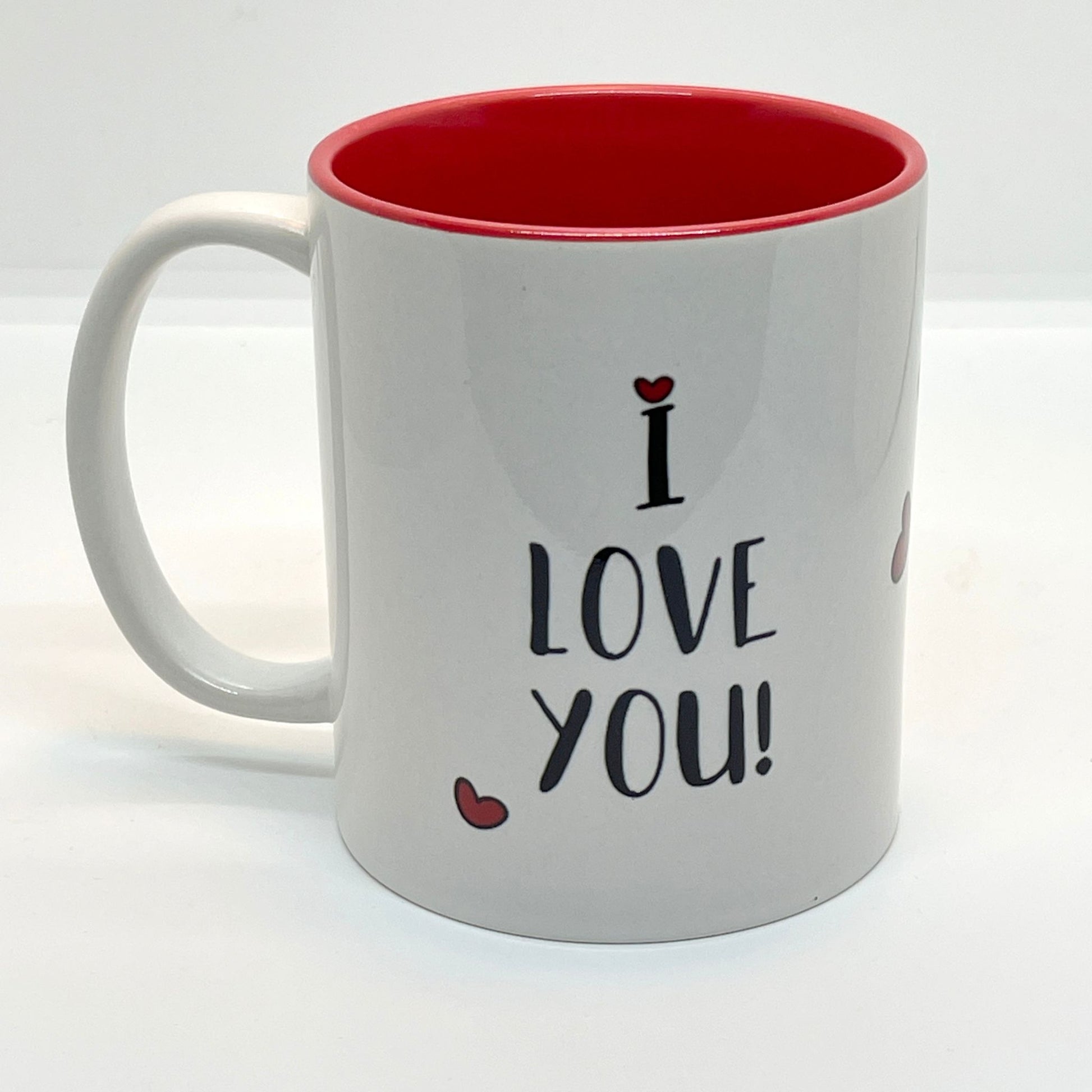 Krus i keramikk med en søt illustrasjon av en smilende panda som holder en bukett med røde hjerter, sammen med teksten "I LOVE YOU".  Innvendig farge på kruset er rødt.