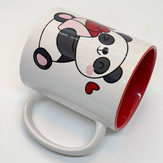 Krus i keramikk med en søt illustrasjon av en smilende panda som holder en bukett med røde hjerter, sammen med teksten "I LOVE YOU".  Innvendig farge på kruset er rødt.