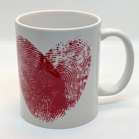 Krus i keramikk med teksten "YOU & ME" og en dristig typografi med et rødt fingeravtrykk-hjerte.