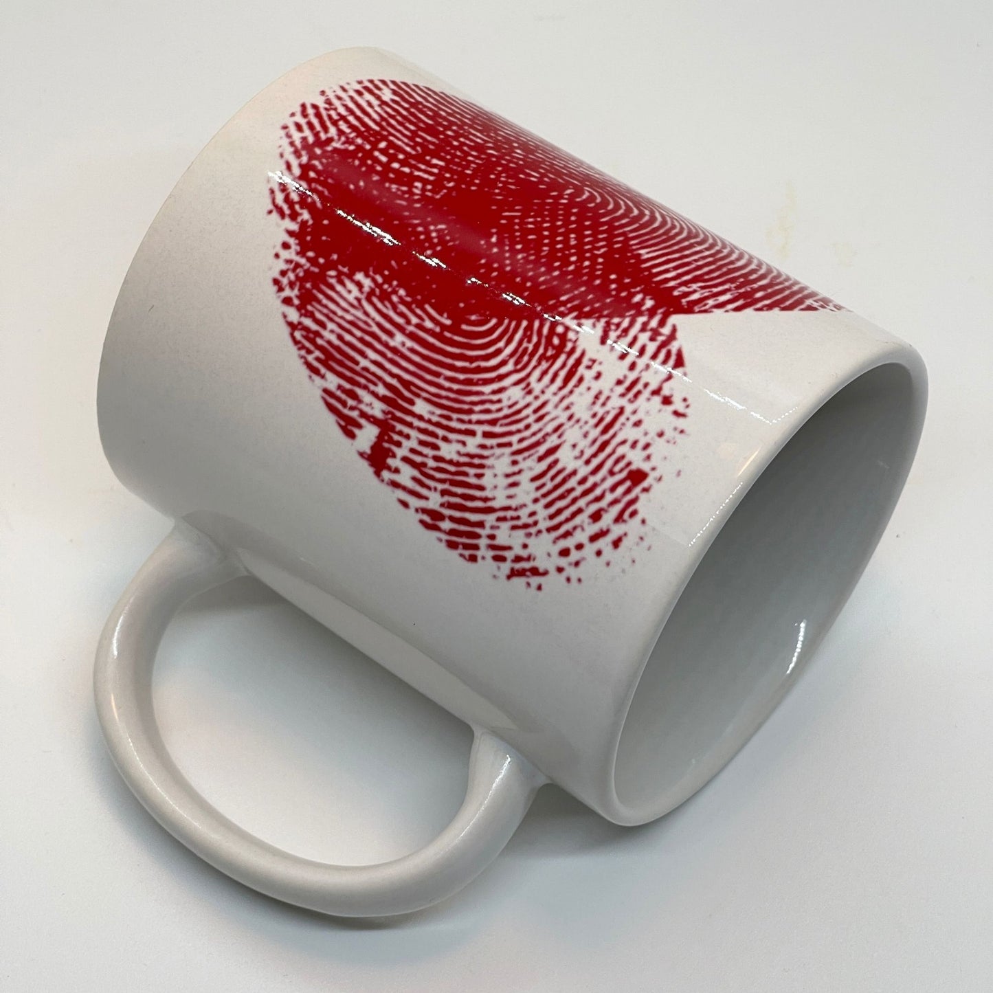 Krus i keramikk med teksten "YOU & ME" og en dristig typografi med et rødt fingeravtrykk-hjerte.