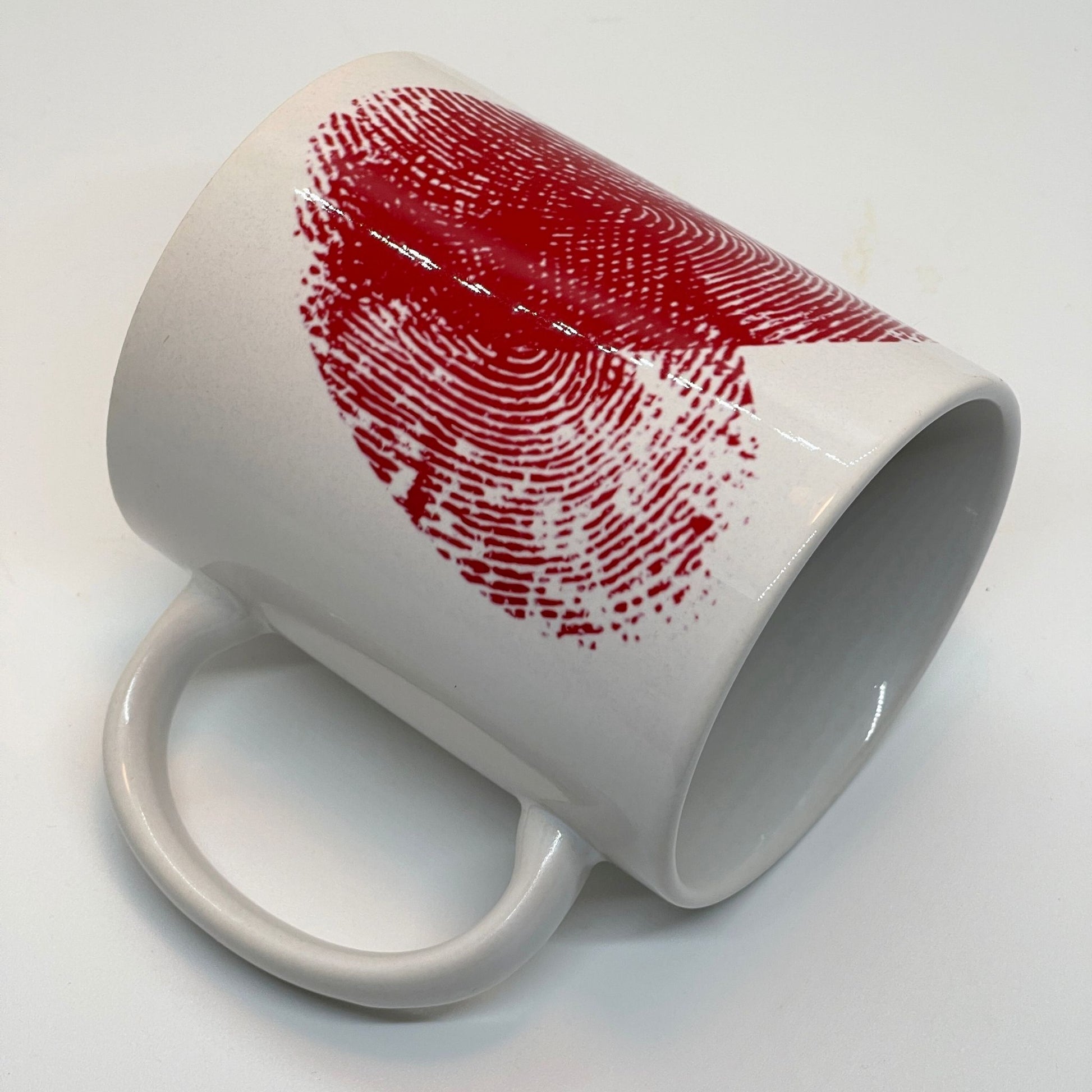 Krus i keramikk med teksten "YOU & ME" og en dristig typografi med et rødt fingeravtrykk-hjerte.