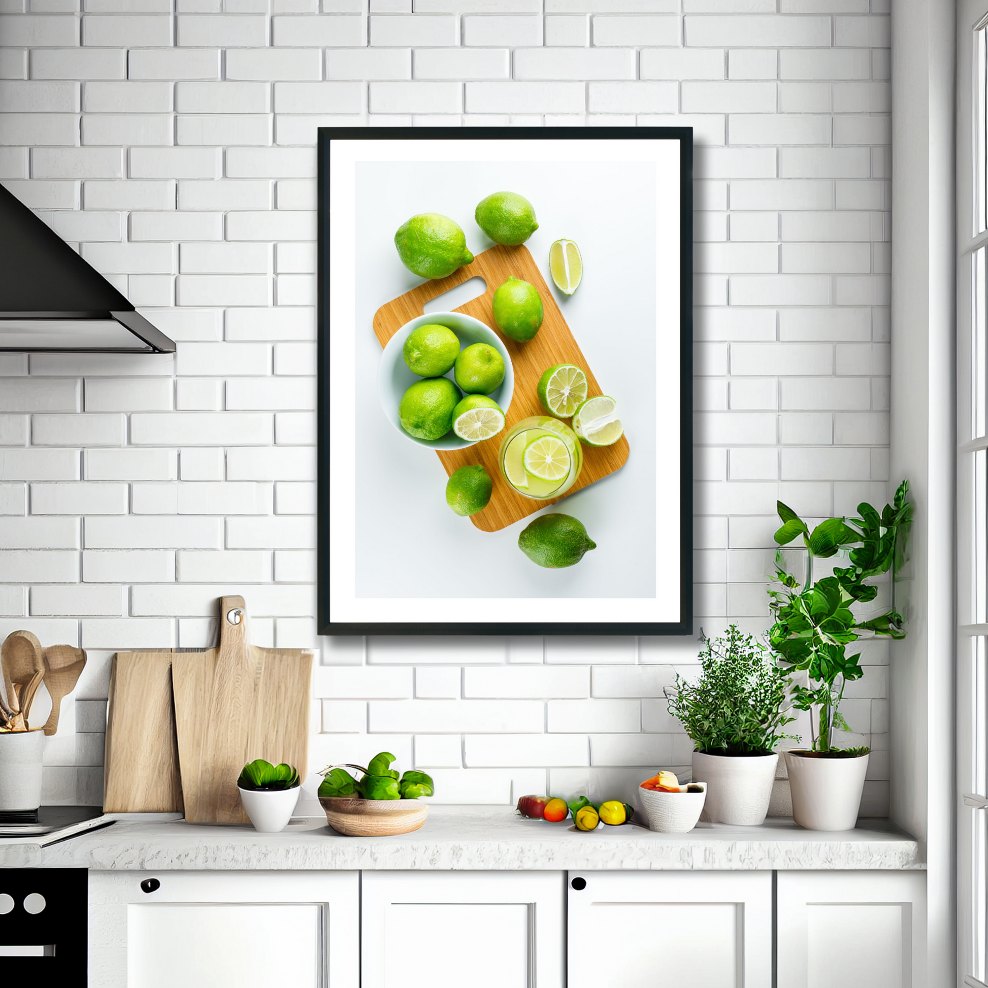 Fotoplakat med motiv av lime , i skiver og i et glass med drikke. Illustrasjonsbilde viser plakat i sort ramme som henger på en vegg over en kjøkkenbenk.