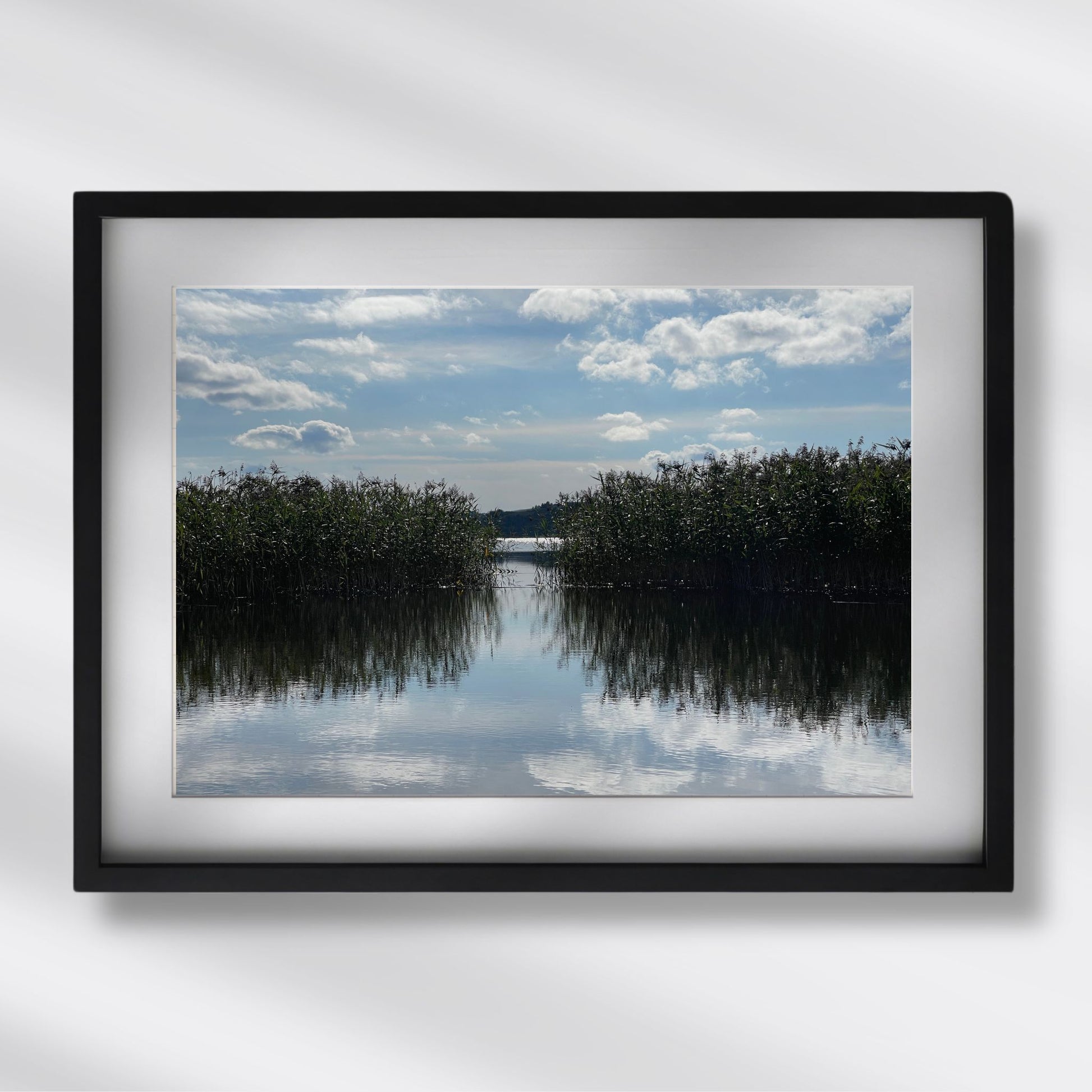 Dette naturmotivet fra Trøndelag er rikt på kontraster og refleksjoner – og gir en følelse av dybde, stillhet og langsom tid.  Illustrasjon viser motivet som plakat med passepartout i sort ramme.