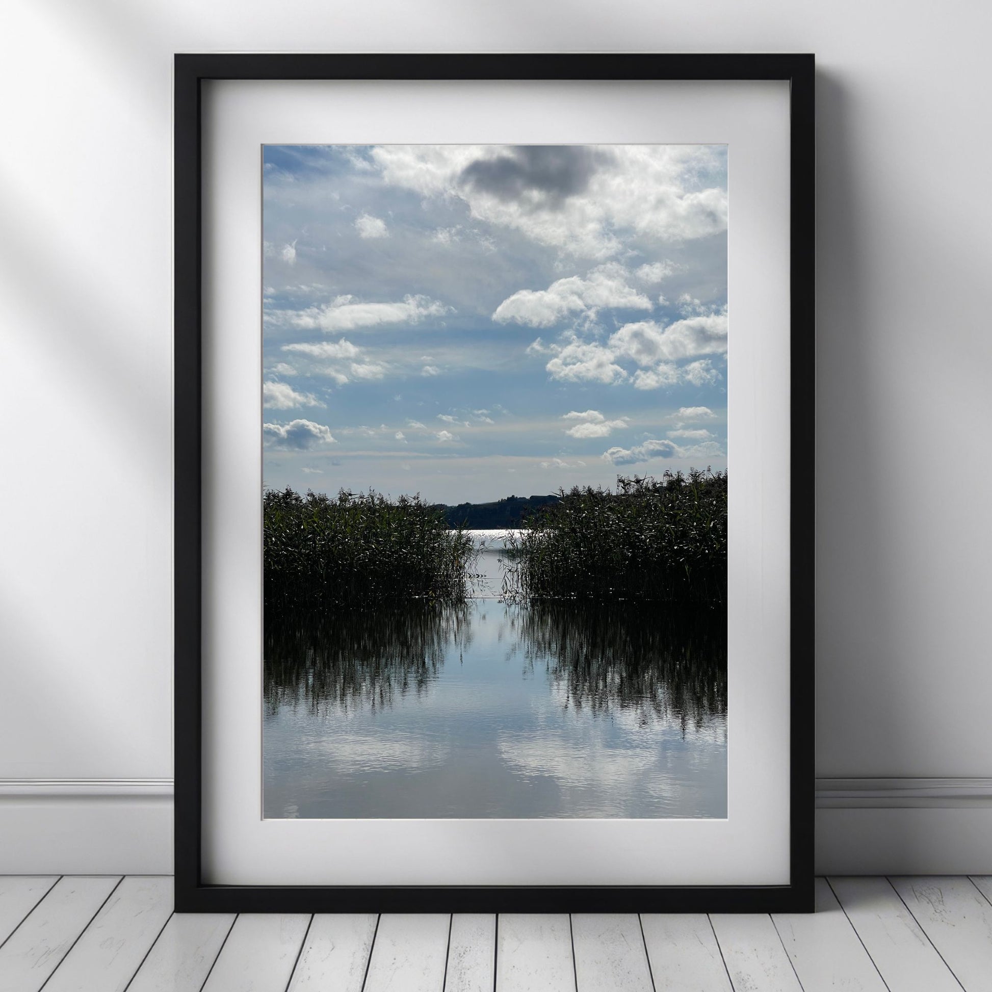 Dette naturmotivet fra Trøndelag er rikt på kontraster og refleksjoner – og gir en følelse av dybde, stillhet og langsom tid.  Illustrasjon viser motivet som plakat med passepartout i sort ramme.
