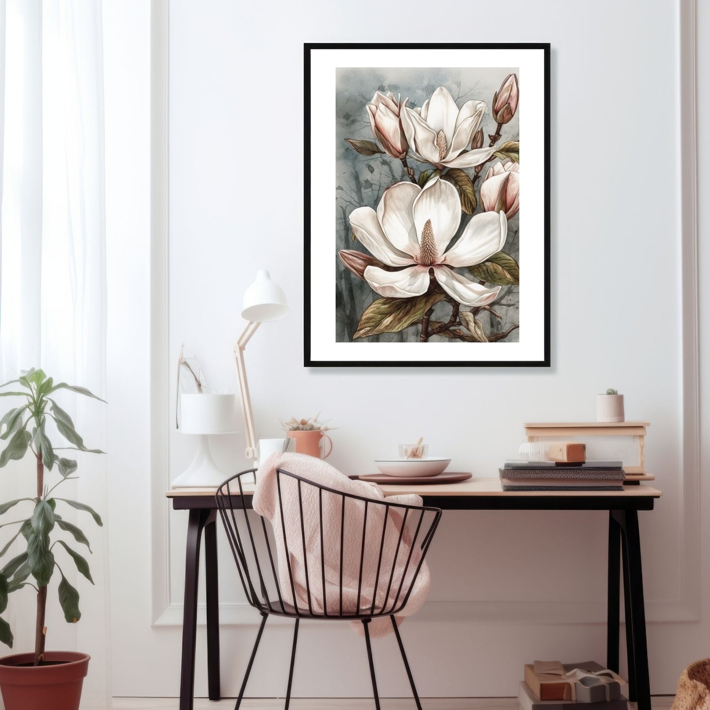 Grafisk motiv av Magnolia blomster trykket på plakat. Rundt bildet er det en dekorativ hvit kant. Illustrasjon viser plakaten i en sort ramme på en vegg over et skrivebord.