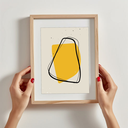 Grafisk abstrakte kunstplakat kombinerer elegant svart og gult på en subtil beige bakgrunn. Illustrasjonsfoto viser plakat i treramme.