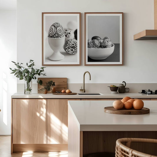 Med håndmalte, kunstneriske påskeegg som motiv, bringer dette settet en minimalistisk og moderne estetikk til enhver vegg. Illustrasjon viser plakatene med hvit kant i rammer av eik på et kjøkken.