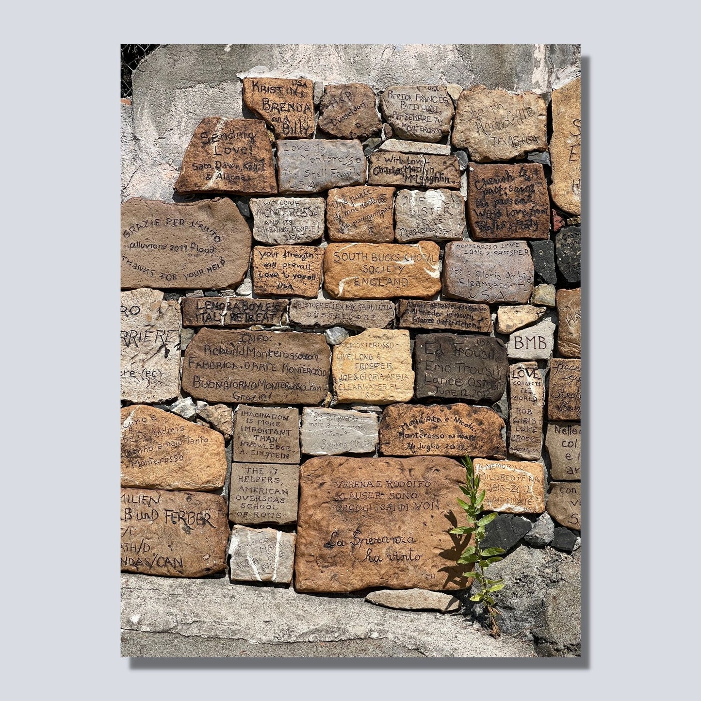 Denne muren ligger ved stien langs sjøen ved Montereosso al Mare, en av de fem byene i Cinque Terre ved Liguriakysten i Italia. Monterosso ligger lengst vestover av de 5 byene. Denne muren er dekorert med hilsener og inskripsjoner fra tilreisende. Plakaten er på dette bildet på lerretsduk.